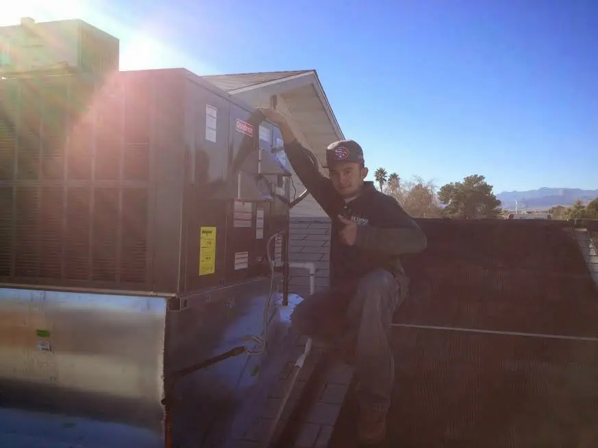 HVAC technician performing AC Tune-Up on a rooftop unit in Gas City
